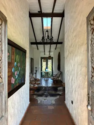 a hallway in a house with a ceiling with a chandelier at Hacienda La Tranquera in Anserma