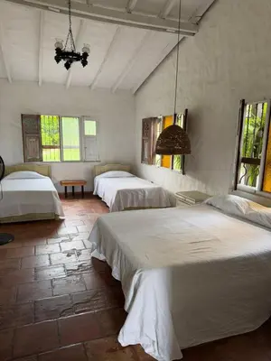 a bedroom with three beds in a room at Hacienda La Tranquera in Anserma