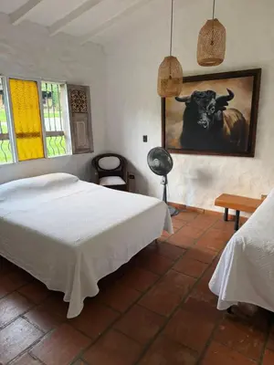 a bedroom with a bed and a picture of a cow at Hacienda La Tranquera in Anserma