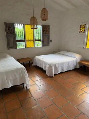 a room with two beds and stained glass windows at Hacienda La Tranquera in Anserma
