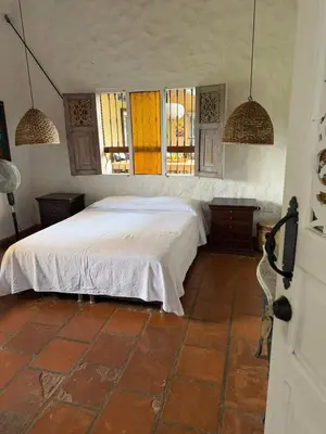 a bedroom with a bed and some windows at Hacienda La Tranquera in Anserma