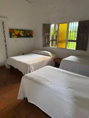 three beds sitting in a room with windows at Hacienda La Tranquera in Anserma