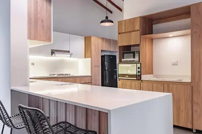 a kitchen with a white counter top and wooden cabinets at NOK Peaceful 3BR in Medellin in Medellín