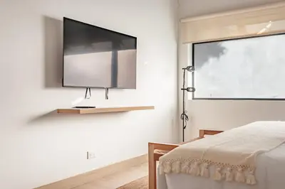 a bedroom with a flat screen tv on the wall at NOK Peaceful 3BR in Medellin in Medellín