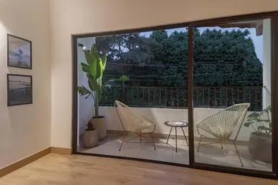 a room with two chairs and a balcony with a large window at NOK Peaceful 3BR in Medellin in Medellín