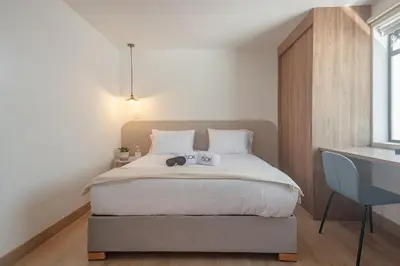 a bedroom with a bed with a desk and a window at NOK Peaceful 3BR in Medellin in Medellín