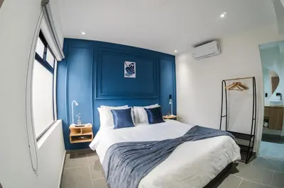 a bedroom with blue walls and a bed with pillows at Fresco Living in Medellín