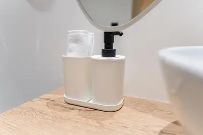 a white soap dispenser sitting on a table next to a toilet at Fresco Living in Medellín