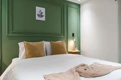 a green bedroom with a bed with a blanket on it at Fresco Living in Medellín
