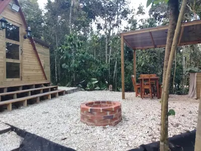 a backyard with a brick fire pit and a cabin at Almonte Glamping in Guarne