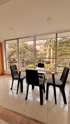 a table and chairs in a room with a large window at Hotel MOVA in Medellín