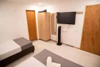 a bedroom with a bed and a flat screen tv at Hotel MOVA in Medellín