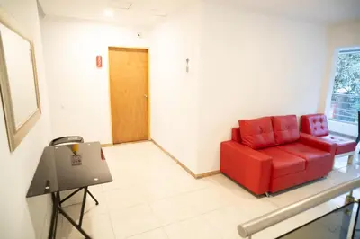 a red chair in a room with a table at Hotel MOVA in Medellín