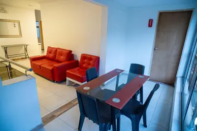 a living room with a table and chairs and a couch at Hotel MOVA in Medellín