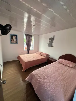 a bedroom with two beds and a window at La Casa de Oliva in Norcasia
