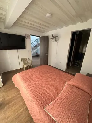 a bedroom with a bed with a orange bedspread at La Casa de Oliva in Norcasia