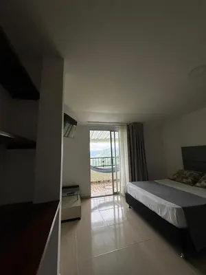 a bedroom with a bed and a sliding glass door at Hotel Boutique El Paisaje in Santa Bárbara