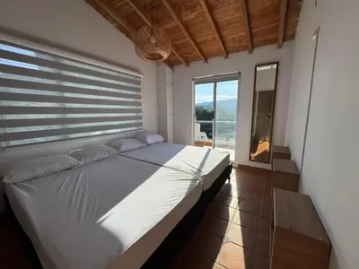 a white bed in a room with a window at Casa Finca en Guatapé in Guatapé