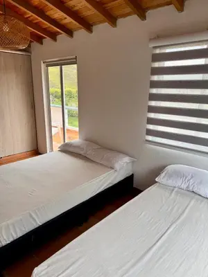 two beds in a room with a window at Casa Finca en Guatapé in Guatapé