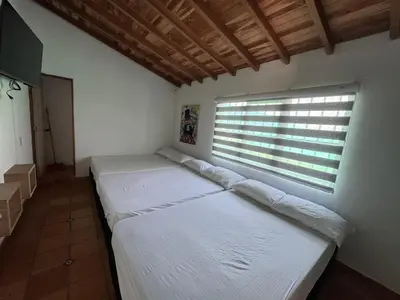two beds in a room with a window at Casa Finca en Guatapé in Guatapé