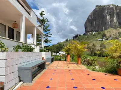 a brick walkway with a bench and a mountain at Casa Finca en Guatapé in Guatapé