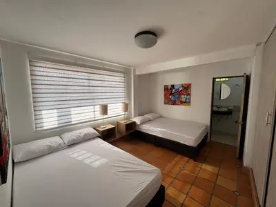 a hotel room with two beds and a window at Casa Finca en Guatapé in Guatapé