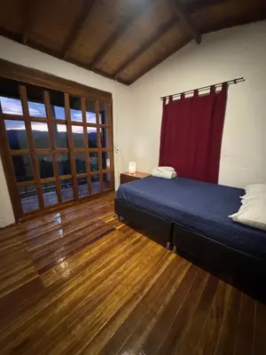a bedroom with a bed and a red curtain at Cabaña descanso in Guarne