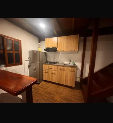 a kitchen with a stainless steel refrigerator and wooden cabinets at Cabaña descanso in Guarne