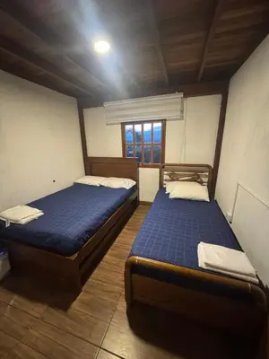 two twin beds in a room with a window at Cabaña descanso in Guarne