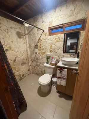 a stone bathroom with a toilet and a sink at Cabaña descanso in Guarne
