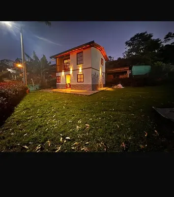 a house with lights on in a yard at night at Cabaña descanso in Guarne
