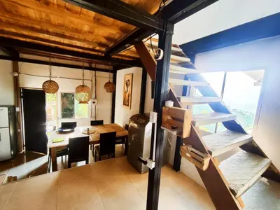 a room with a staircase and a dining room with a table at Balcones de la montaña in El Limón