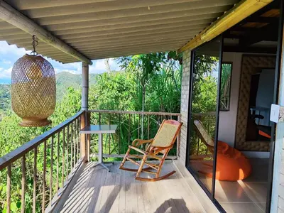 a room with a balcony with a chair and a table at Balcones de la montaña in El Limón