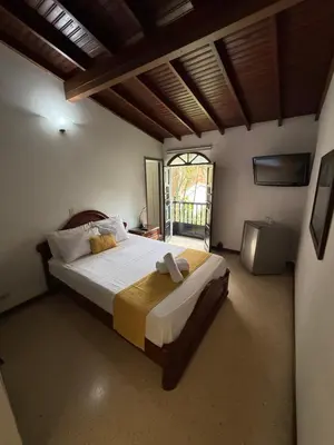 a bedroom with a large bed and a window at Hotel Balcones De Malibu in Medellín