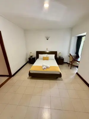 a bedroom with a bed with a yellow blanket on it at Hotel Balcones De Malibu in Medellín