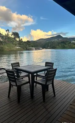 a table and two chairs sitting on a dock near the water at Cabaña flotante con jacuzzi in Guatapé