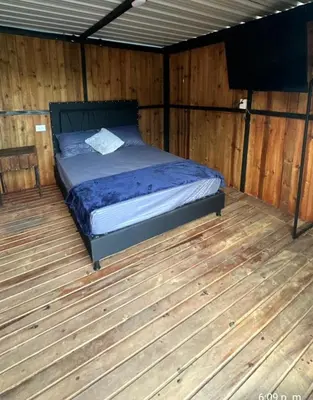 a bed in a room with a wooden floor at Cabaña flotante con jacuzzi in Guatapé
