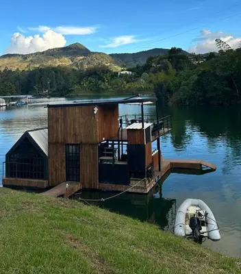 a small house on a dock on a lake at Cabaña flotante con jacuzzi in Guatapé