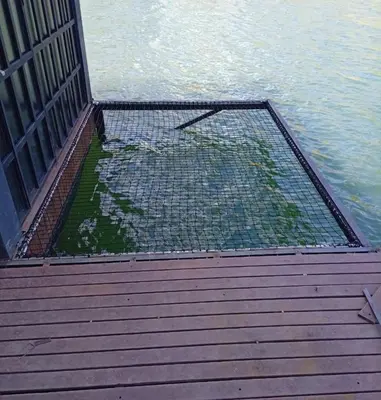 a net on a boardwalk next to the water at Cabaña flotante con jacuzzi in Guatapé