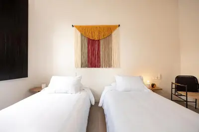 two white beds in a room with a window at Hotel Boutique Casamía in Medellín
