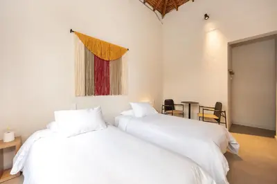 two white beds in a room with a window at Hotel Boutique Casamía in Medellín