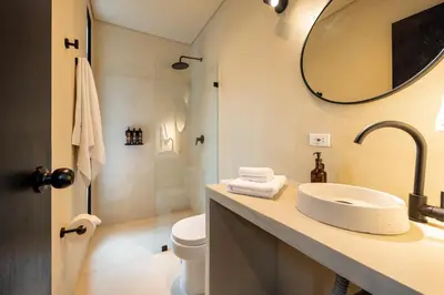 a bathroom with a sink and a toilet and a mirror at Hotel Boutique Casamía in Medellín