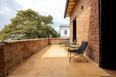 a balcony with chairs and a brick wall at Hotel Boutique Casamía in Medellín