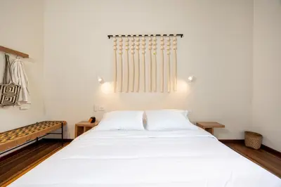 a bedroom with a large bed with white sheets at Hotel Boutique Casamía in Medellín