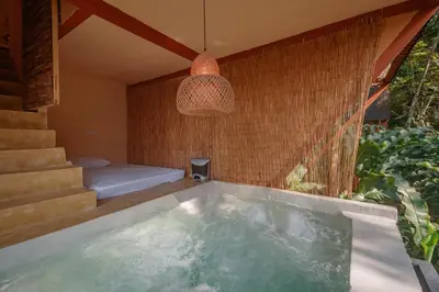 a bath tub in a room with a bed and a lamp at Cabaña El Mamoncillo - Jacuzzi Privado con Calefacción y Malla Catamarán - Cerca a Medellín in Sopetran