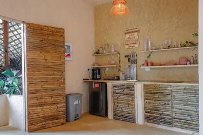 a kitchen with a counter and a refrigerator at Cabaña El Mamoncillo - Jacuzzi Privado con Calefacción y Malla Catamarán - Cerca a Medellín in Sopetran