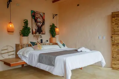 a bedroom with a large bed and two plants at Cabaña El Mamoncillo - Jacuzzi Privado con Calefacción y Malla Catamarán - Cerca a Medellín in Sopetran