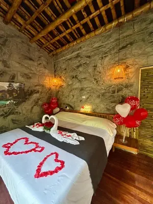 a bedroom with a bed with red decorations on it at Cabaña El Bosque - En medio del bosque - Jacuzzi Privado con Calefacción y Malla Catamarán - Cerca a Medellin in Sopetran