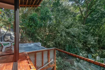 a screened in porch with a hammock and trees at Cabaña El Bosque - En medio del bosque - Jacuzzi Privado con Calefacción y Malla Catamarán - Cerca a Medellin in Sopetran