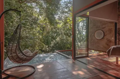 a room with a hammock on a patio with trees at Cabaña El Bosque - En medio del bosque - Jacuzzi Privado con Calefacción y Malla Catamarán - Cerca a Medellin in Sopetran